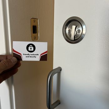 Friendly Locksmith and Security card beside a residential deadbolt